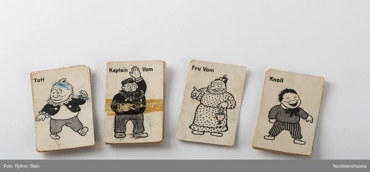 Kortstokk for 4 personer; 4 kort med Knoll, 4 kort med Tott, 4 kort med kaptein Vom og kun to kort med fru Vom. Spilleregler følger med.