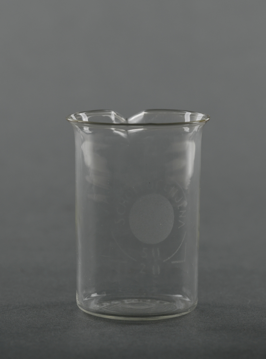 Et begerglass av borosilikatglass. Det er sylindrisk med en liten helletut oppe på kanten. Begeret er av typen "Schott Cenjena". Slike glass tåler høy varme, kjemikalier og temperaturforandringer og egner seg til kjemiske eksperiment og lignende. Det rommer 50 ml.