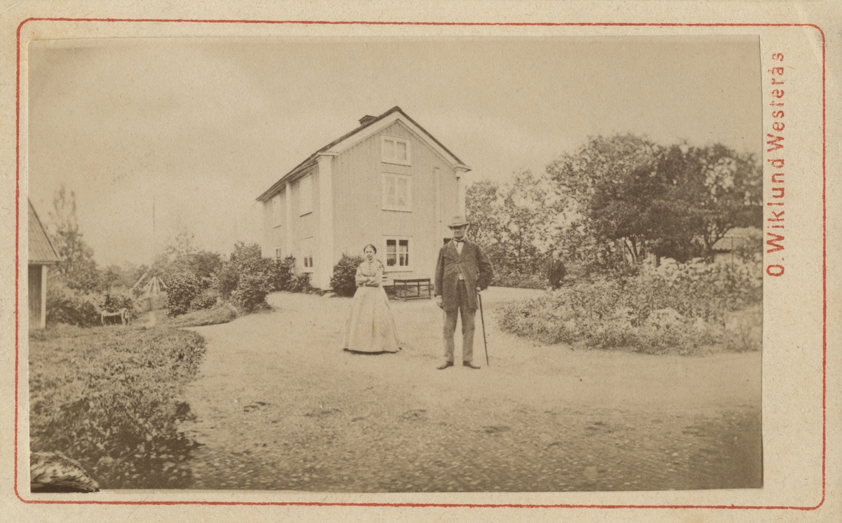 I bild står grosshandlare Per Olof Flodin (1806-1886) och hans hustru Lovisa Eugenia Holmberg (1817-1894). I bakgrunden syns Blåsbo nedre.