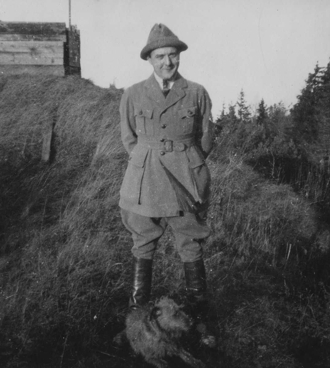 Porträttfoto av militären Nils Kindberg med hund framför framför militär anläggning, 1924.

Text vid foto: "'NK. BK."