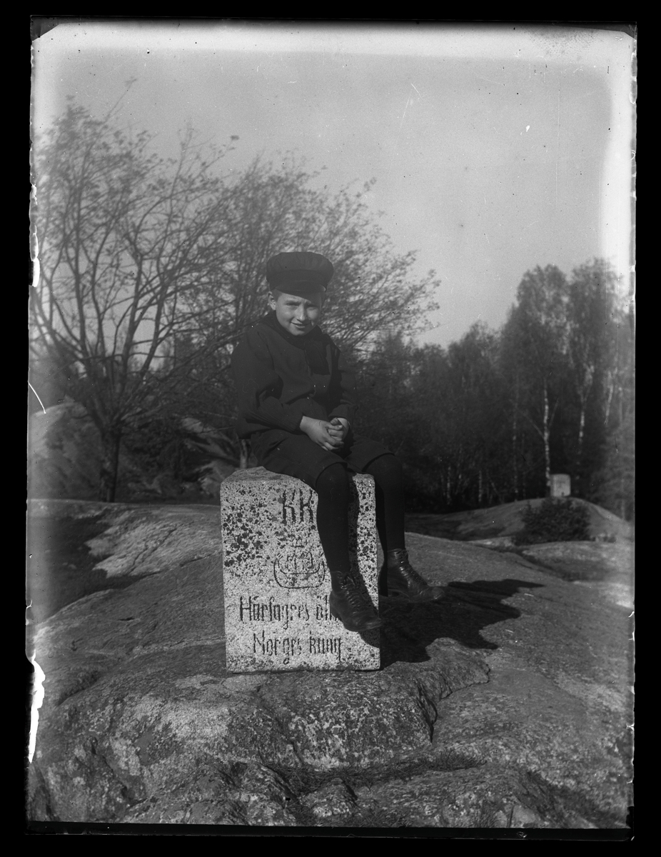 Pojke sitter på en sten, Djäkneberget, Västerås.