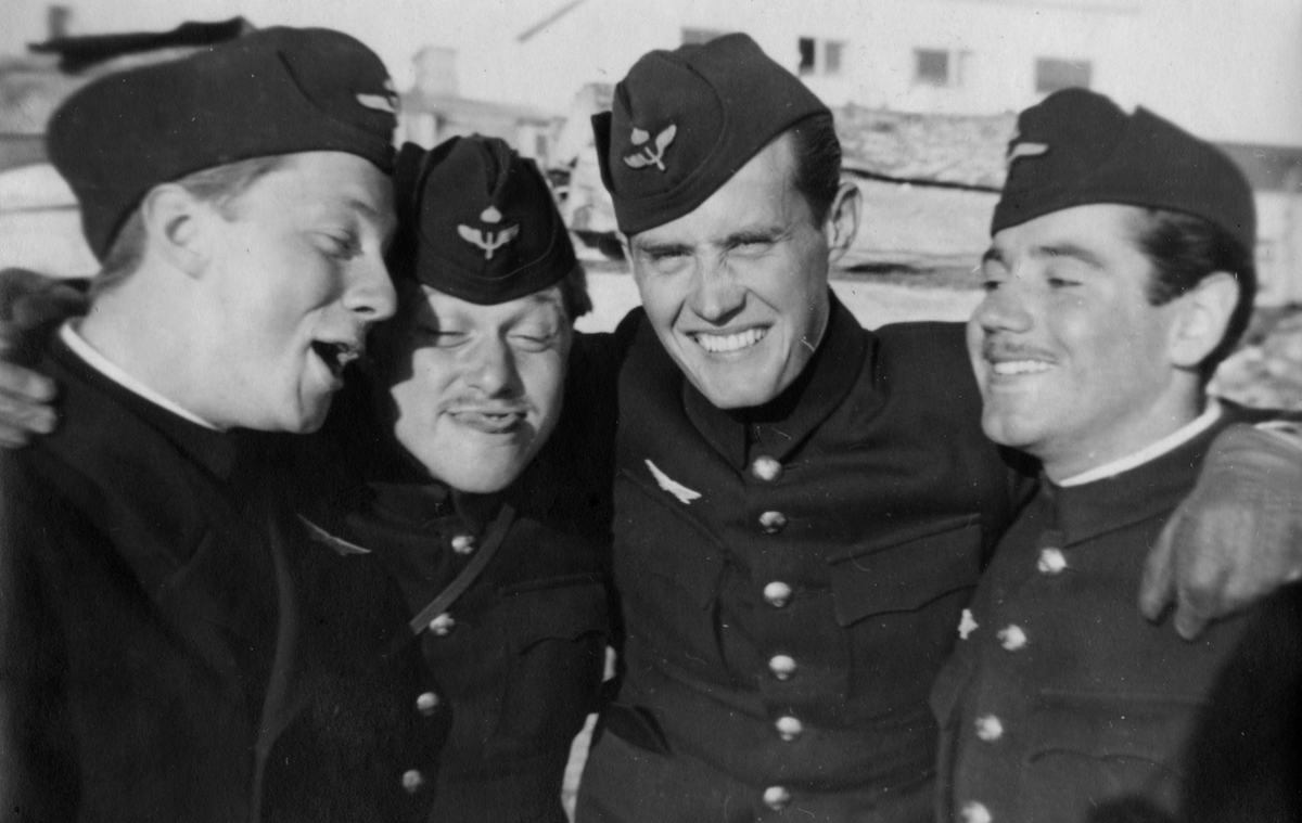 Porträttfoto av fyra glada flygsoldater på F 21 Kallax, cirka 1942.

Bildtext vid foto: "Kallax. Vi hade roligt nästan jämt."

Foto skannat ur album: 'Minnen från Min kommistid 1940-1944'