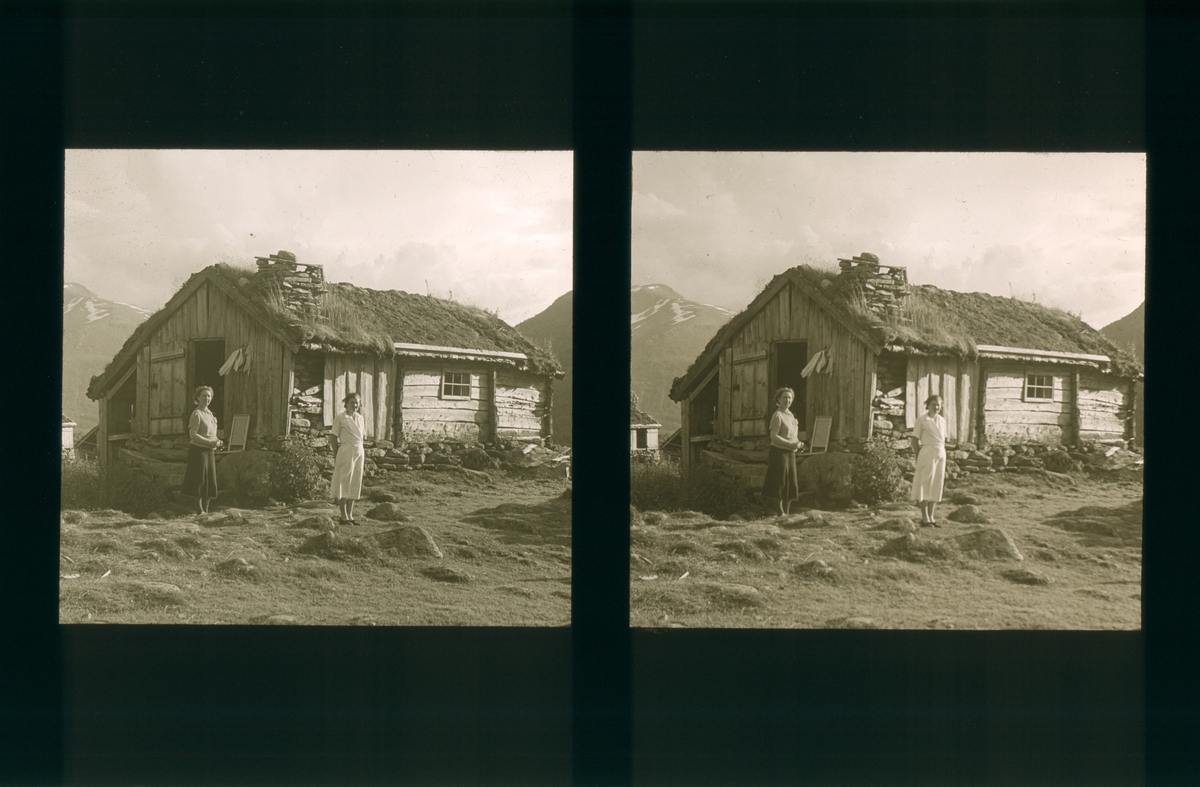 To kvinner ved et gammelt stølhus. Kvitlen seter i Møre og Romsdal. Tilhører Arkitekt Hans Grendahls samling av stereobilder.