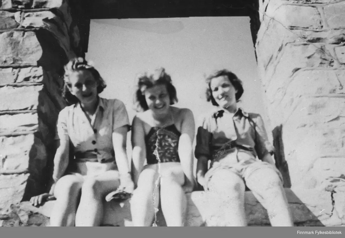 Her poserer tre kvinner fra Alta vegkontor, for fotografen i sommervarmen, i Halde i Alta 1947. Fra venstre ser vi Martha Joki Mach, Randi Thomassen og en ukjent.