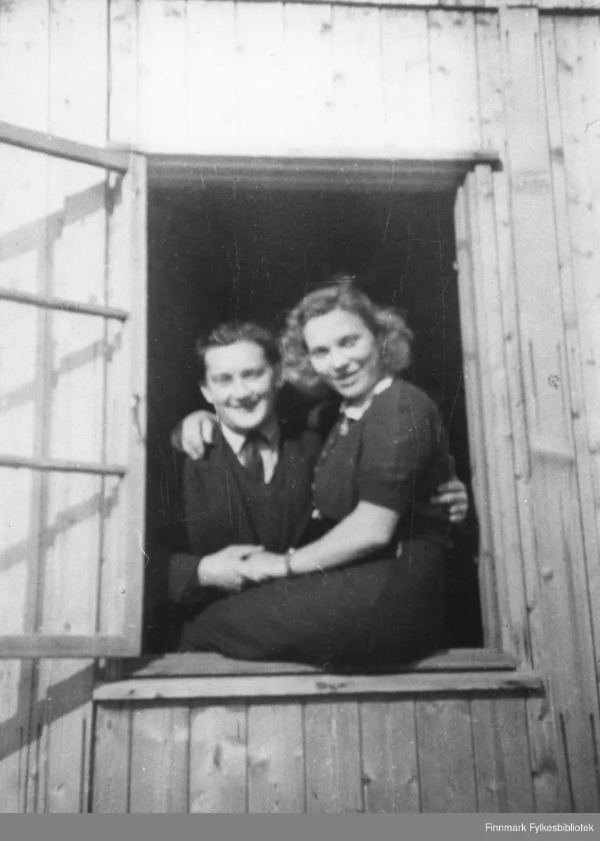 Kristian Arnesen og Anne Lise Posti, fotografert i vinduskarmen på vegkontoret i Elvebakken i Alta, ca. 1947.