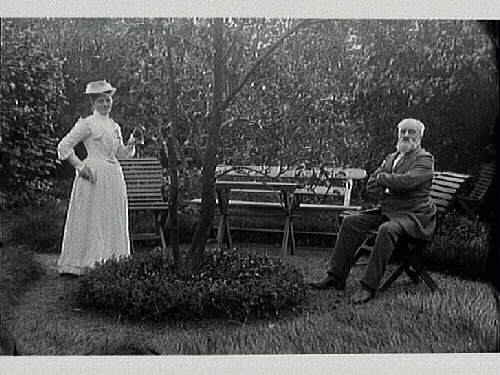 Musikdirektör Alfred Lundgren med hushållerskan Anna Bäckström, fotograferade i trädgården på fastigheten Klockaren 18, Bäckgatan, Varberg.