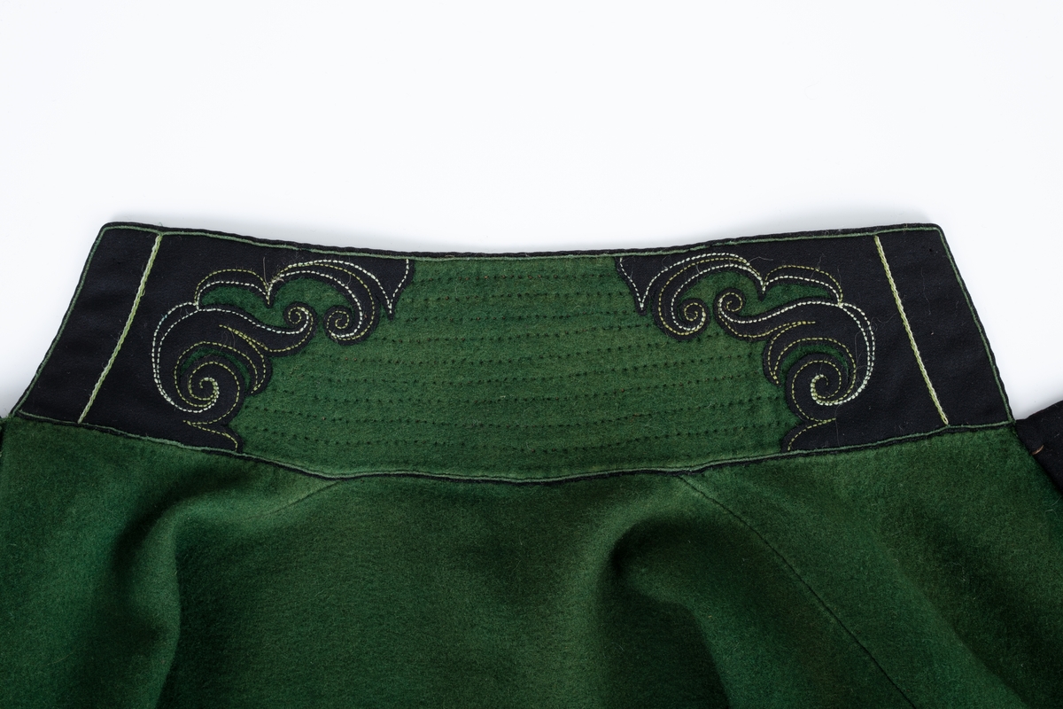 Grønn trøye av vadmel med dekor av svart klede, sølvknapper.