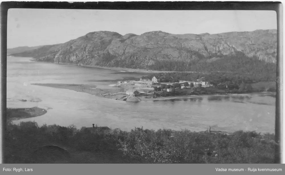 Landskapsmotiv fra ukjent sted. Bebyggelse på begge sider av sjøen. Bildet har tilhørt Lars Rygh fra Hønefoss. Han var med på minerydding i Varangerfjorden 1917 - 1918.