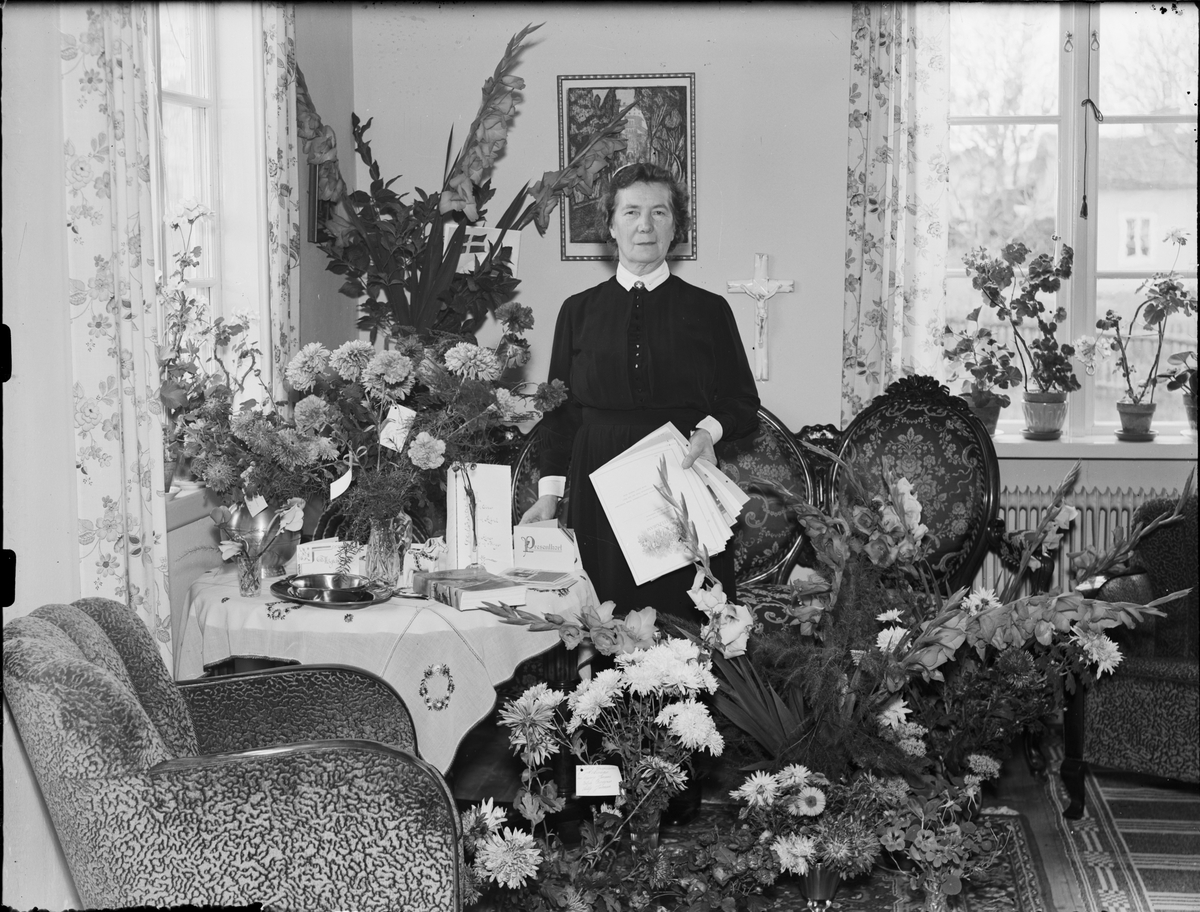 Evy Andersson omgiven av blommor, Östhammar, Uppland 1935