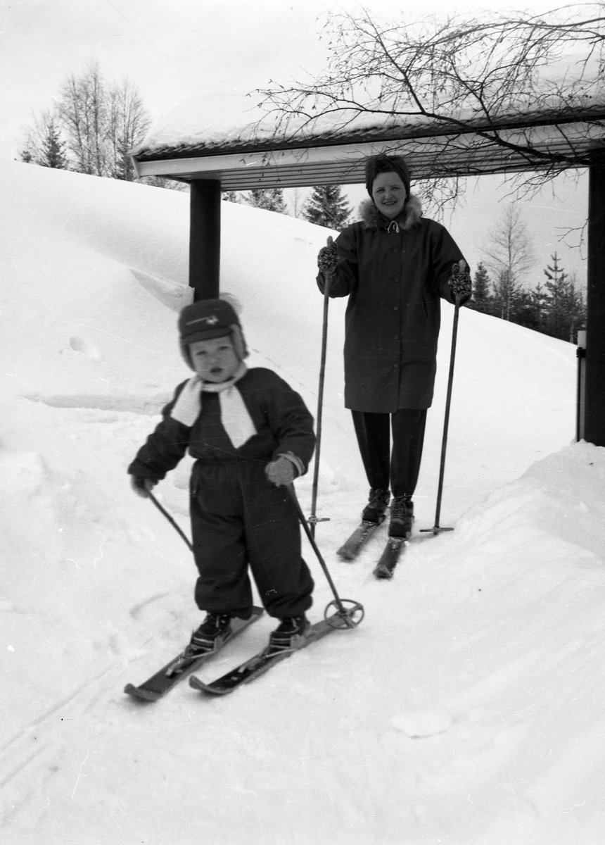 En kvinne og liten gutt på ski.