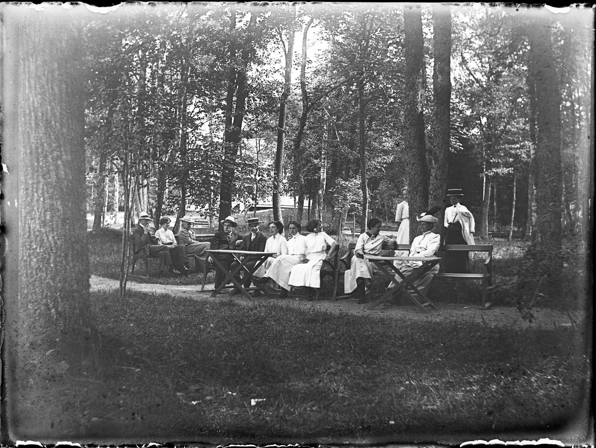 Kvinnor och män i parken vid Sätra brunn, Sala