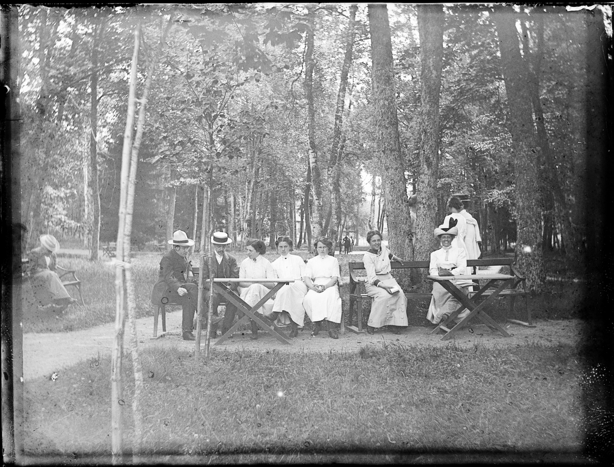 Kvinnor och män i parken vid Sätra brunn, Sala