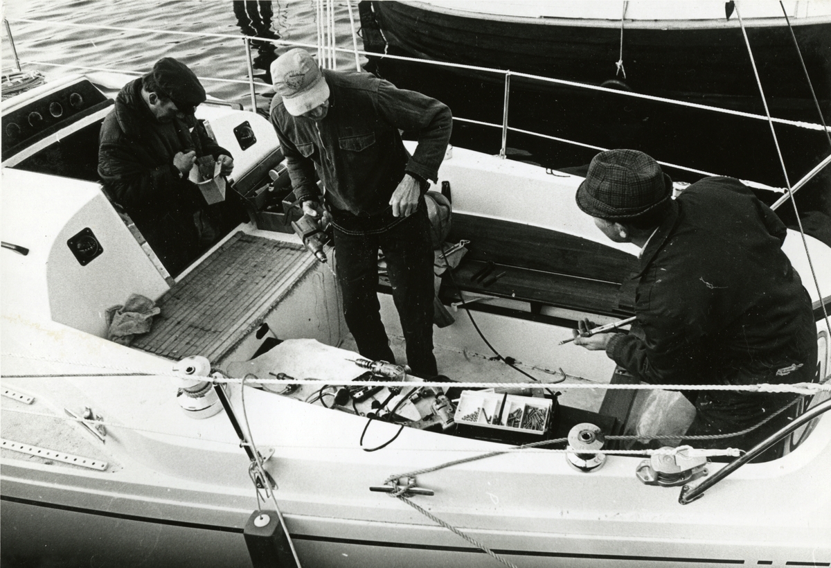 Tre menn ombord på Linge-båten Gambling. Sansynligvis ved Fevik brygge, Grimstad.