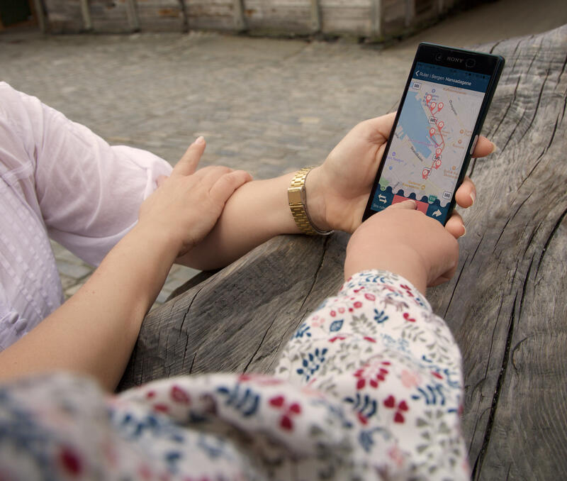 to personer ser på en mobil som viser appen "maritim vandring".
