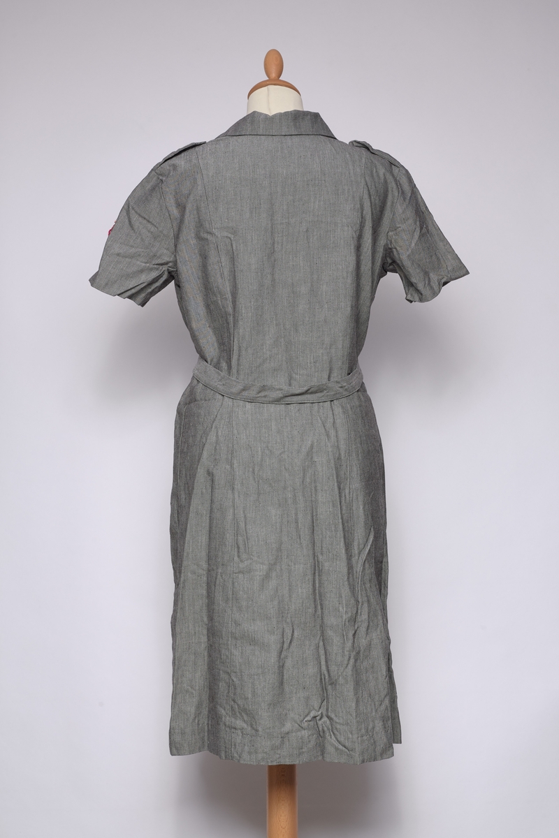 Lottekjole med belte og tre luer. Knappene i kjolen er merket med NLF.