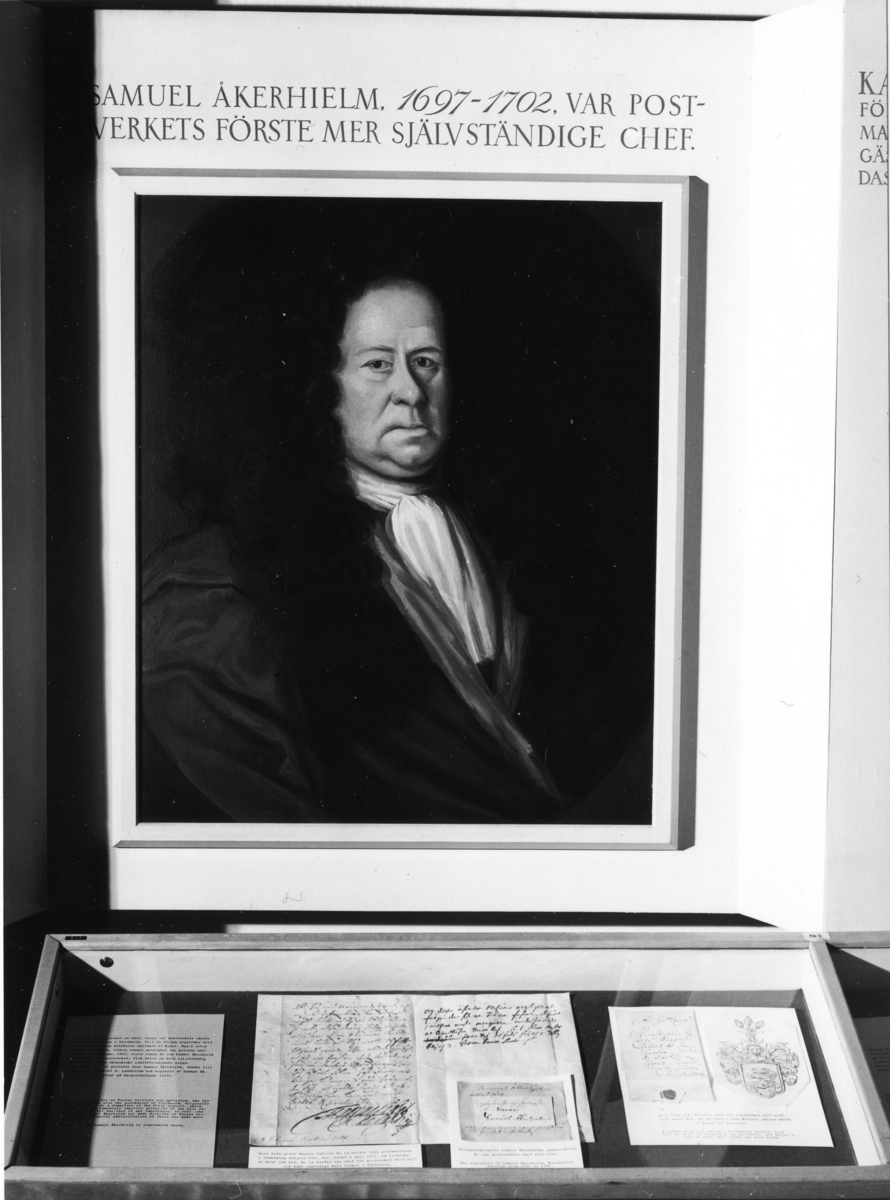Skärm med text: "Samuel Åkerhielm, 1697-1702, var postverkets
förste mer självständige chef" samt ett porträtt av Åkerhielm efer en
målning. I montern nedanför bl a brev med anknytning till Åkerhielm.