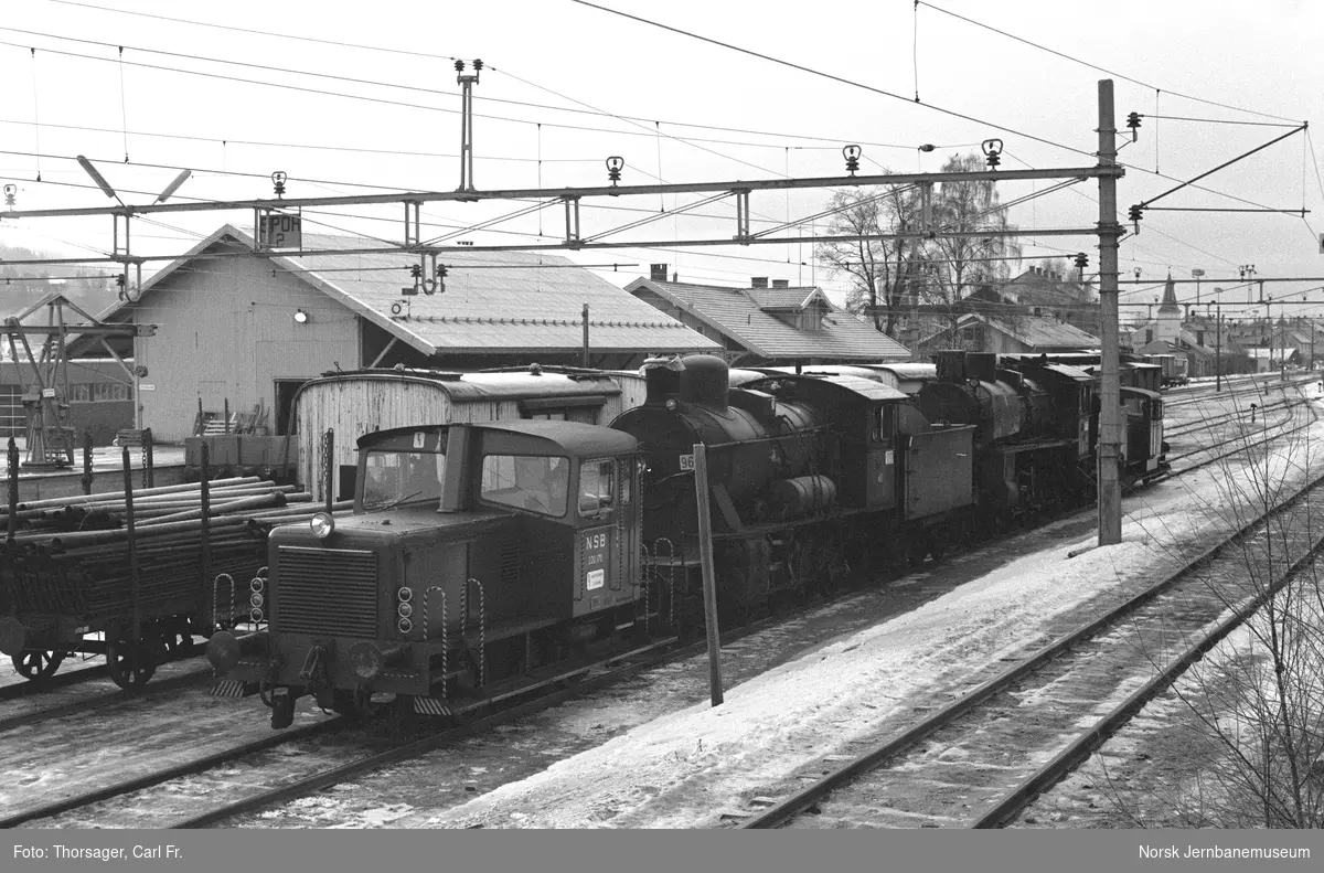 Skiftetraktor Skd 220 170 (nærmest) og Skd 214 84 med damplokomotivene 26c 411 og 24b 236 på Vikersund stasjon. Toget er underveis til Kløftefoss på Krøderbanen