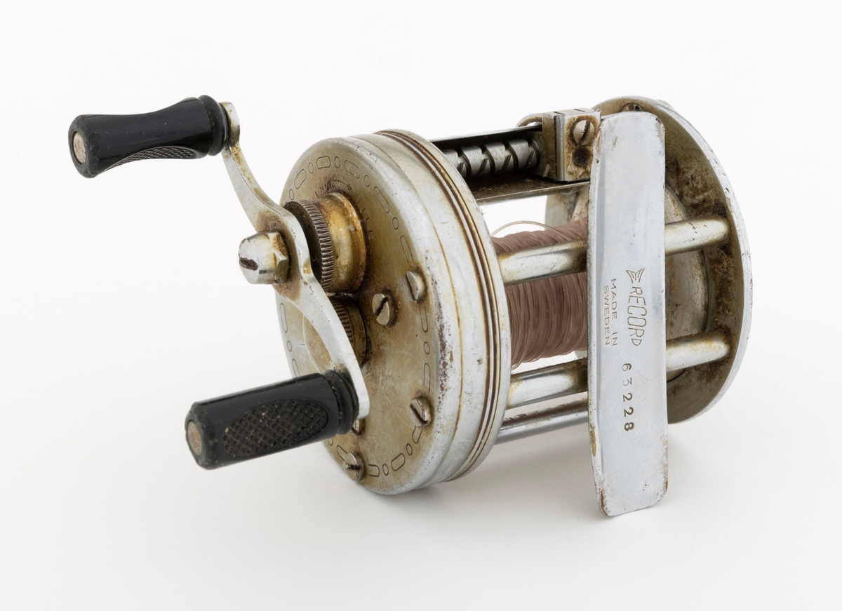 Fiskesnelle, multiplikatorsenelle, brukt på stang. Snella er en ABU Record No 1800. Snella har sveiv i blankt metall med svarte sveivknapper i bakelitt. Snellehusets sidedeksler er utført i blankt metall, med tverrgående metallstag. Det sitter igjen grått snøre, nylonsene, på spolen. Ut fra informasjon fra giver/bruker er ikke snella komplett, det er brukt noen deler av den, f. eks. mangler to sporskruer i ene sideplaten.  

Fra boka "Sportsfiskeleksikon" (2005) kan en bl. a. lese om multiplikatorsneller: "Multiplkatorsnella er bygd rundt selve spolen med et snellehus som beskytter drev og bremser. Snellehuset er tradisjonelt bygd med sidedeksler  og tverrgående stag, men mindre sneller har gjerne helstøpte snellehus. Foran spolen løper snøreføreren på evighetsskruen, mens sveiv og juseringsskruer er montert på sidedekslene. Frikoplingsknappen kan enten sitte på sidedeksel eller som en tommeltangent bak spolen."