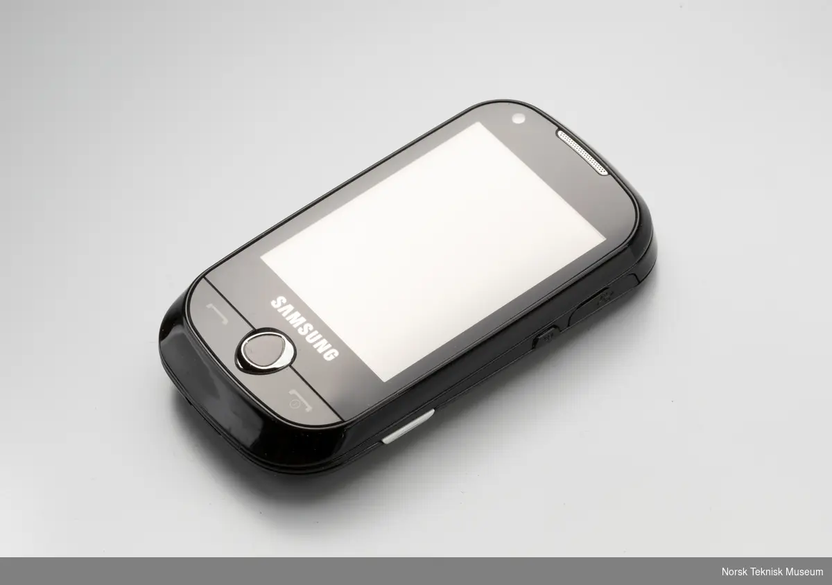Mobiltelefon med brukerhåndbok (fire eksemplarer), to deksler, lader, øreplugger samt ledning, batteri og 2 cd`er. Alt i original emballasje.