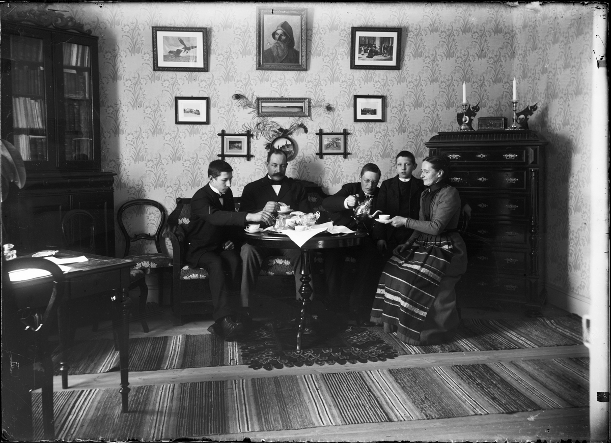 Familjen Henriksson runt kaffebordet i finrummet, Skolgården