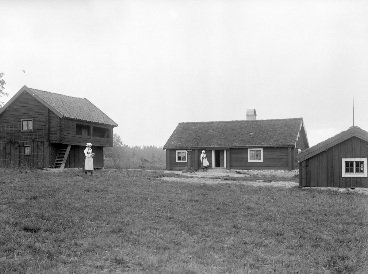Motiv från hembygdsgården till Lunnevads folkhögskola. Byggnaderna flyttade till platsen från Egeby i Västerlösa socken. Bild från omkring 1920.
