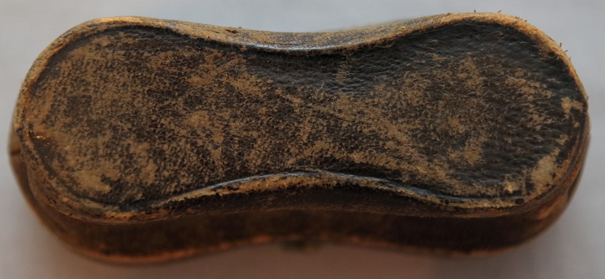 Kikare i fodral. Kikaren är utfällbar och är  gjord i mässing, ben och glas. Fodralet har en stomme av trä, är täckt på utsidan av skinn klädd i rött tyg innuti. På insidan av locket är det med guldig text tryckt "H. Samson Stockholm" (optiker från Stockholm under det sena 1800-talet). Fodralet har en låsmekanism med en liten knapp på utsidan med en inristad blomma och borrade dekorativa hål på.