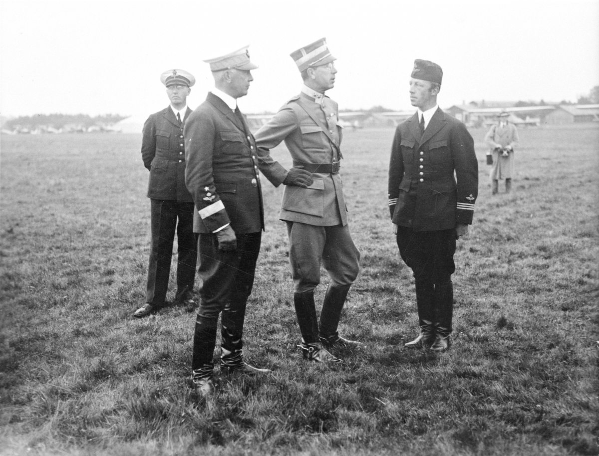 Inspektion av flygskolan F 5 i Ljungbyhed den 9 september 1932. Fyra högre militärer på flygfältet. Från vänster flottiljintendent Romander, chefen för flygvapnet Eric Virgin, kronprins Gustaf Adolf och Nils Söderberg.