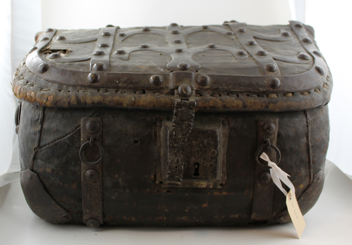Postväska/ koffert med många brevtag. 

Väskan är gjord av flätad rotting och trä, täckt av läder och järnbeslag. Järnhandtag på sidorna och kort bärrem baktill.