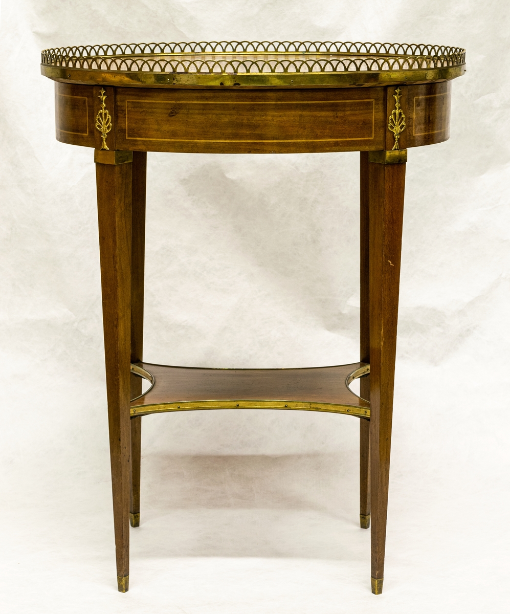 Bord, ovalt, av mahogny med nyckelskylt, beslag, dekorlister och genombruten kant av mässing. Låda i sargen. Gustaviansk stil. Tillhör Rettigska samlingen.