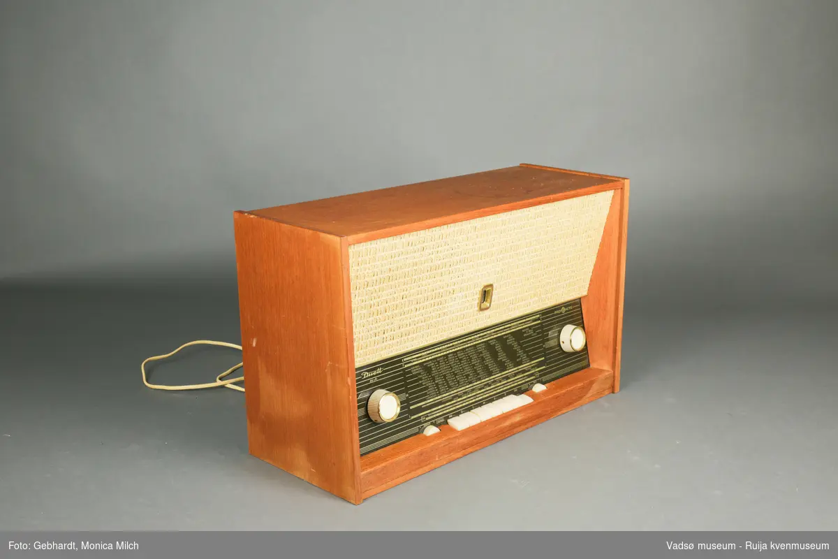 Stor treradio fra Radionette. Radioen har en glasskjerm på framsiden. På bakveggen, som kan tas av, er detaljene om radioen og bruken av den skrevet ned.
