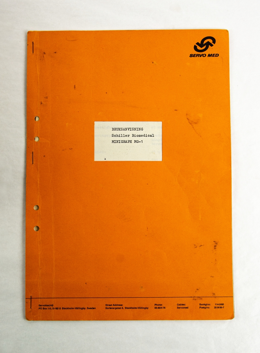 Minigraph MG-1, EKG apparat tillverkad av Schiller Biomedical Schwitzerland. Första EKG apparat i helikopter 4 på 1960-talet. Förvaras i papplåda med handskriven manual.