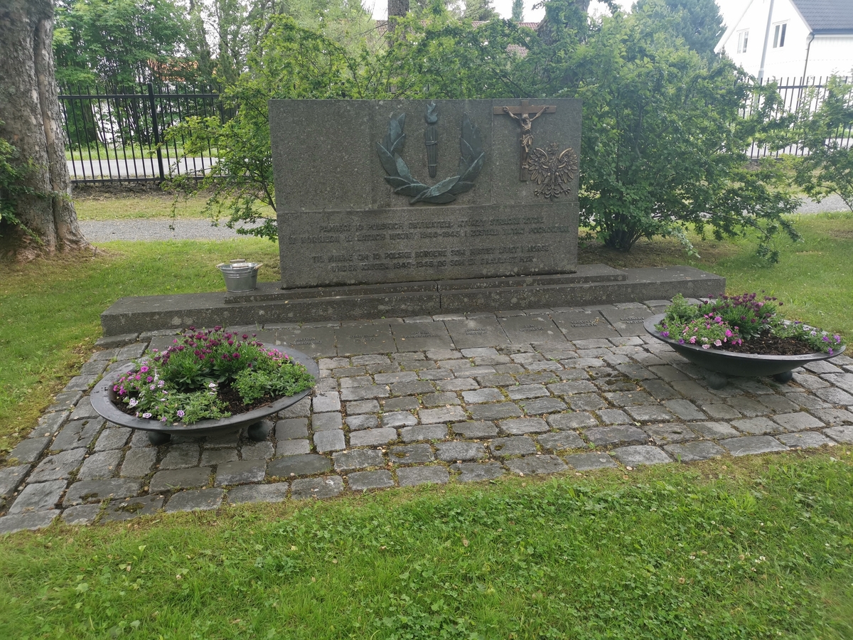 De polske krigsgravene på Moholt kirkegård i Trondheim. Hovedmonument med liggende navneplater foran.