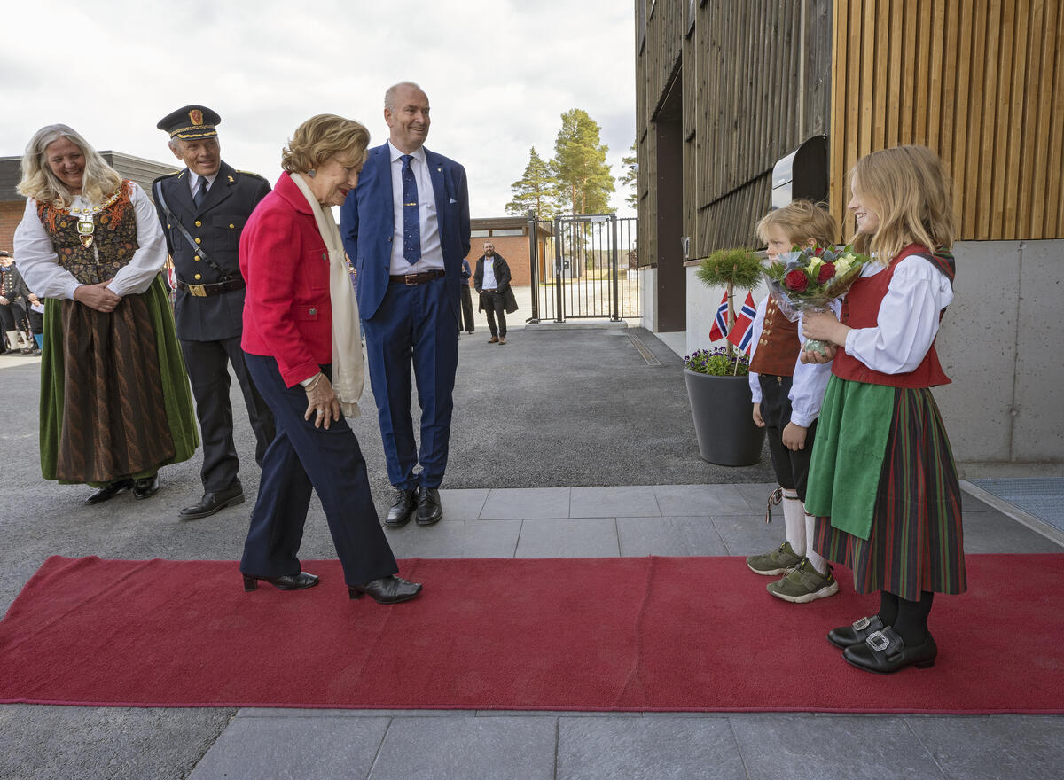 H.M Dronning Sonja blir tatt i mot av to barn under åpningen av Anno bevaringssenter