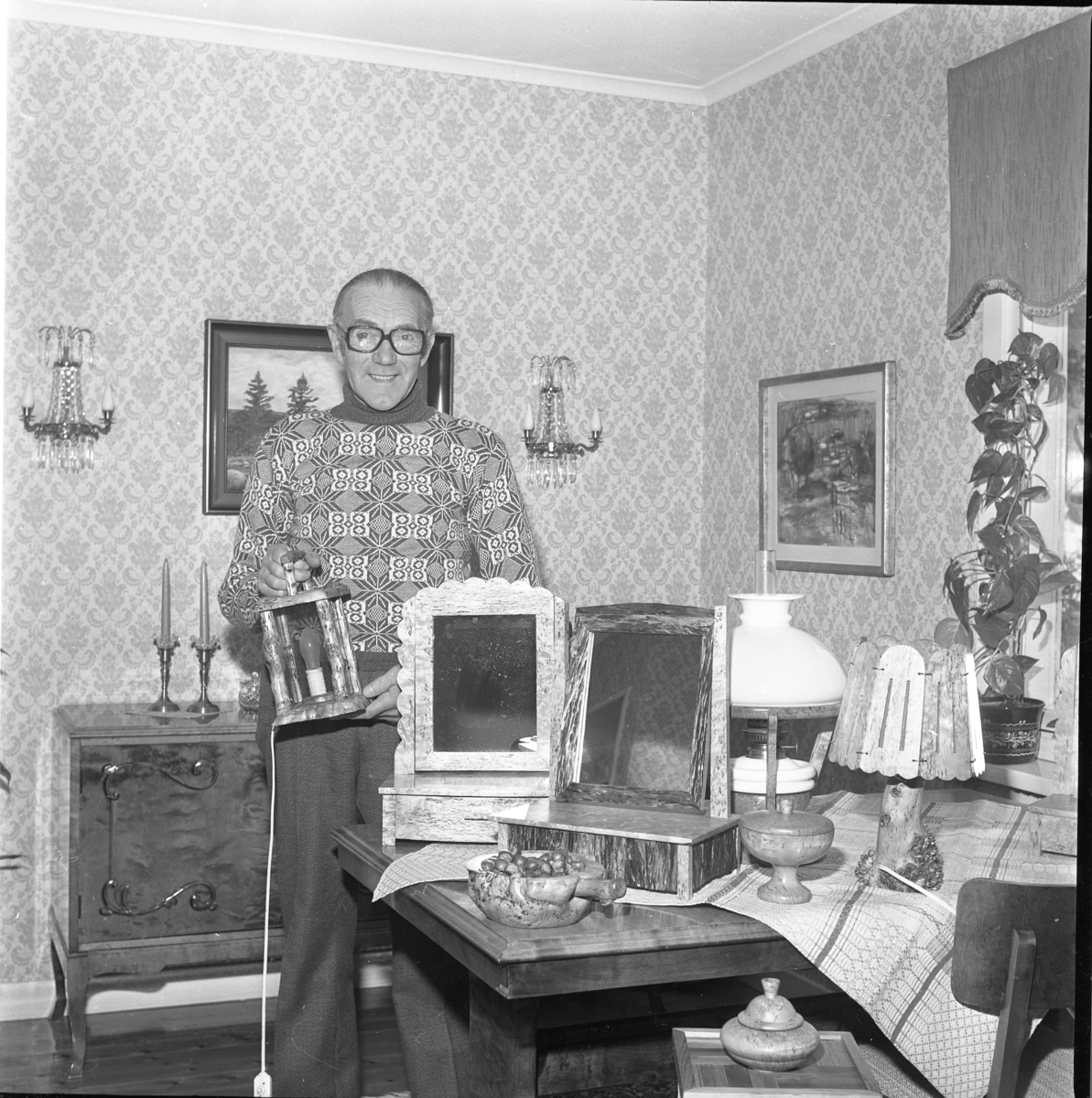 En man står i sitt hem omgiven av föremål, bland annat pigtittare. skålar och lampor. Förmodligen tillverkade av honom själv. Han håller en elektrifierade lykta i handen.
