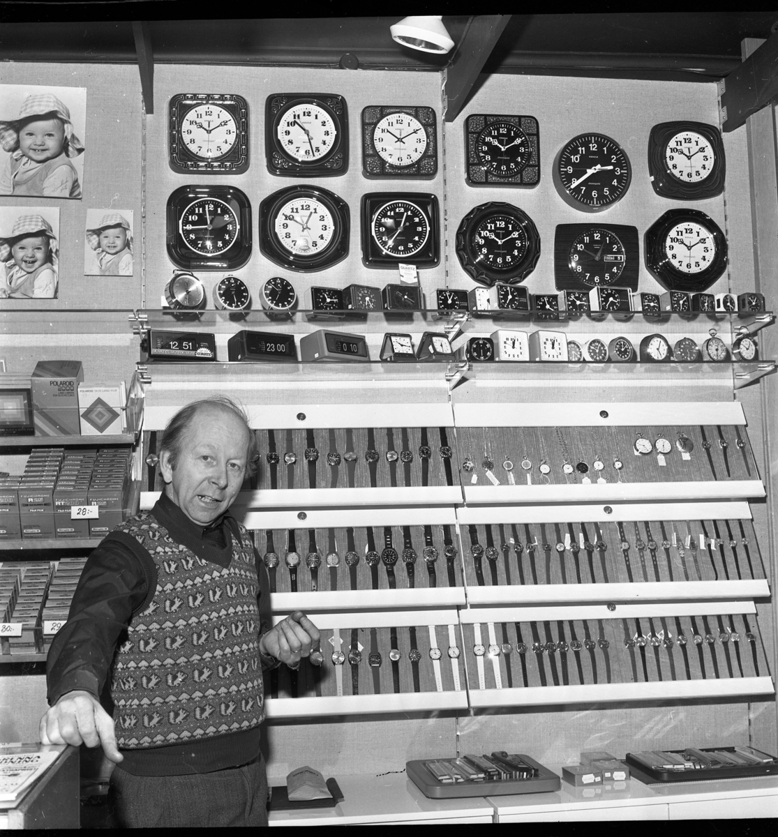 En foto- och klockhandlare står i sin butik på Brahegatan i Gränna. Det är premiär för försäljning av klockor.