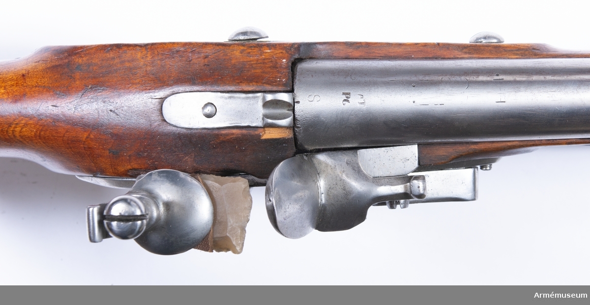 Gevär med flintlås, reparationsmodell 1815.
Låset märkt "CS", pipan märkt "AT PG S". Pipor från div äldre svenska gevär, som ändrats till likhet med 1815 års pipor. Lås från diverse äldre svenska och utländska gevär, som om så behövdes försetts med varhake. I övrigt som 1815 års gevär.