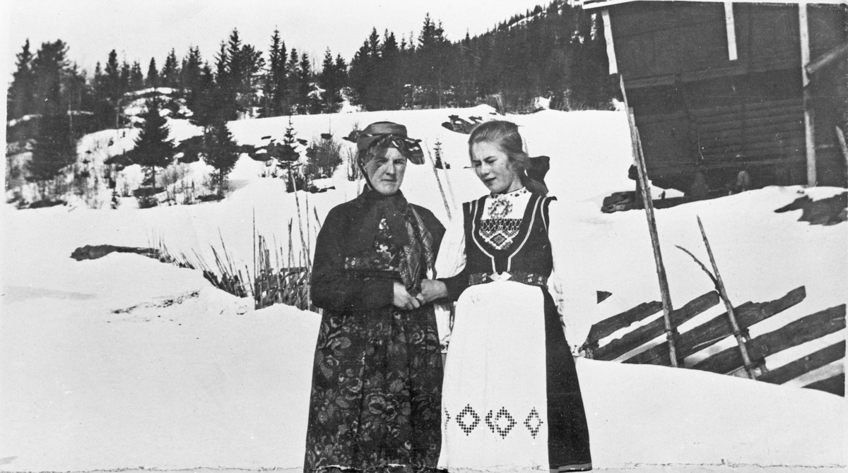 Ingeborg Rugland i gammel drakt fra Eggedal og Bolette Vinnord i Hardangerdrakt. Fotografert på Rugland i Eggedal, 1920-årene.