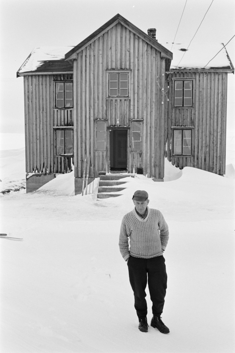 En mann står i snøen utenfor et bolighus på Røros.