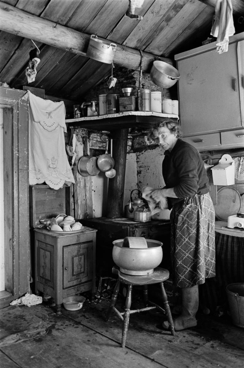 En kvinne vasker opp i et kjøkken på Røros.