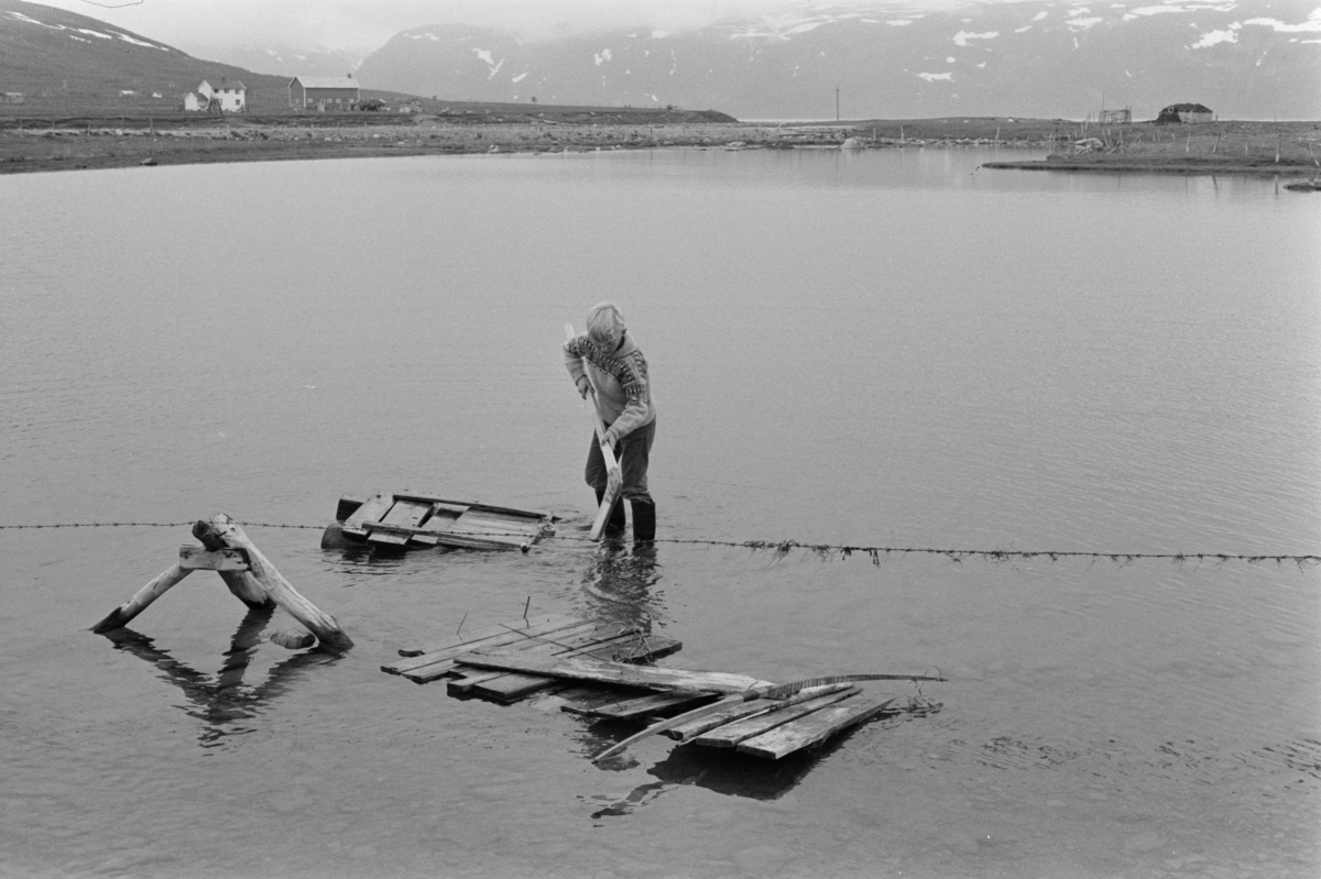 En gutt leker på en flåte i vannet