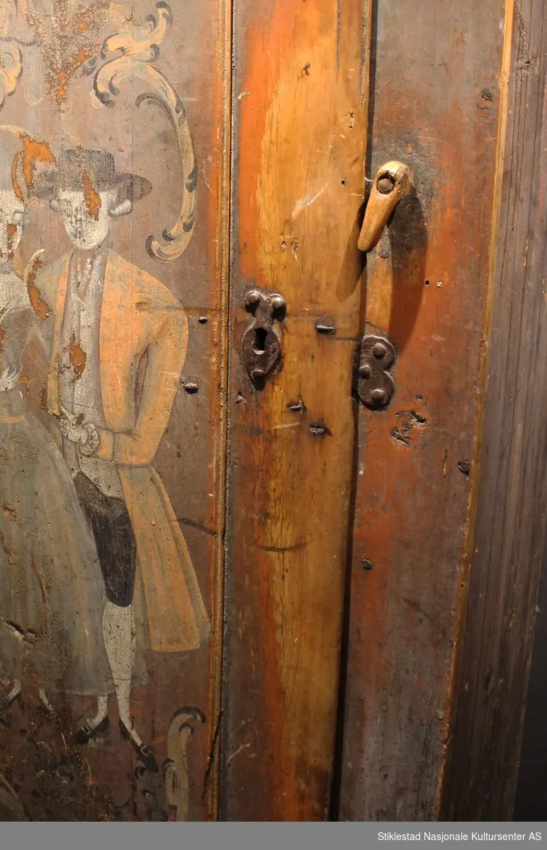 Matskapet dekorert med rosemaling og figurmaling av «rokokkomaleren» Ole Haldosen Berg (1747-1828). 
Gesimsen øverst på sideveggene er fjernet, og spikrene på hengslene er skiftet ut, ellers er skapet intakt med originale beslag (festet på nytt?). Motivet på døra viser et par i finstasen med rokokkoranker rundt. Øverst på døra står bokstavene TES.MJD. Over døra står årstallet 1755, men dette er overskrevet med bokstavene N.O.S.M..E.T.D.M og årstallet 1789. Vi antar at S og D i begge tekstene står for sønn og datter, og at dette er initialene til eierparene, som har skiftet i 1789.
Skapet har en del slitasje på høyre side av døra, ved låsen, etter åpning og lukking av skapet. Etter høyden på disse slitesporene å dømme, har også de minste vært inne i matskapet en del i løpet av årene. Helt nederst vises også hull etter mus som har gnagd seg inn på jakt etter mat. Baksiden av skapet er grovt tilvirket, her vises tydelige spor etter bearbeiding med både øks og pjål/skjøve. Målene på skapet er 170x45x92 cm. Innvendig har skapet tre hylle, mangler nøkkel
