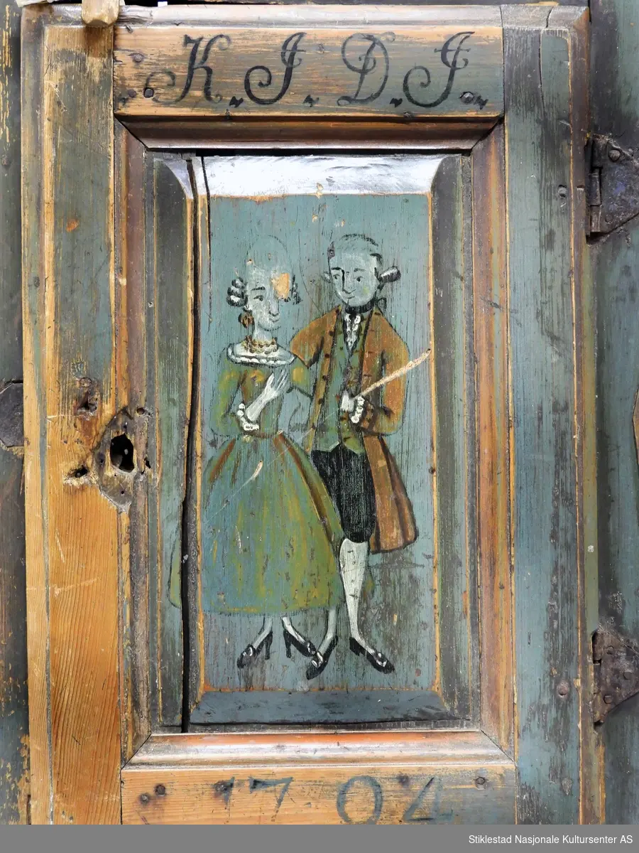 Hengeskapet dekorert med rose- og figurmaling av «rokokkomaleren» Ole Haldosen Berg (1747-1828). Skapet er i bondestil med ei dør i front. Malte speiltfelt. Skapet har liggende profiler i forskjøvet rektangel, disse er dekorert med malt blomsterdekor (hevet over skapets overflate). Over og under dør er profilene montert horisontale, vertikale på høyre og venstre side av dør. Speilfeltet på dør er dekorert med figurmaling, mann og dame i rokokkoklær. Over døra er det montert en vrider i tre, dette for å holde døra lukket. Døra har originale hengsler, nøkkelbeslag mangler, løs låskasse. Grunnfargen er blå. Innvendig har skapet to hyller. 
Gesimsen øverst på sideveggene er fjernet, og spikrene på hengslene er skiftet ut, ellers er skapet intakt med originale beslag (festet på nytt?).
