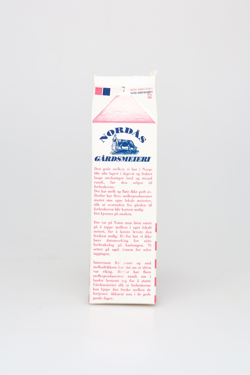 Pappkartong brukt til melk. Rosa farge med ruter. Bilde av en budeie med en ku.