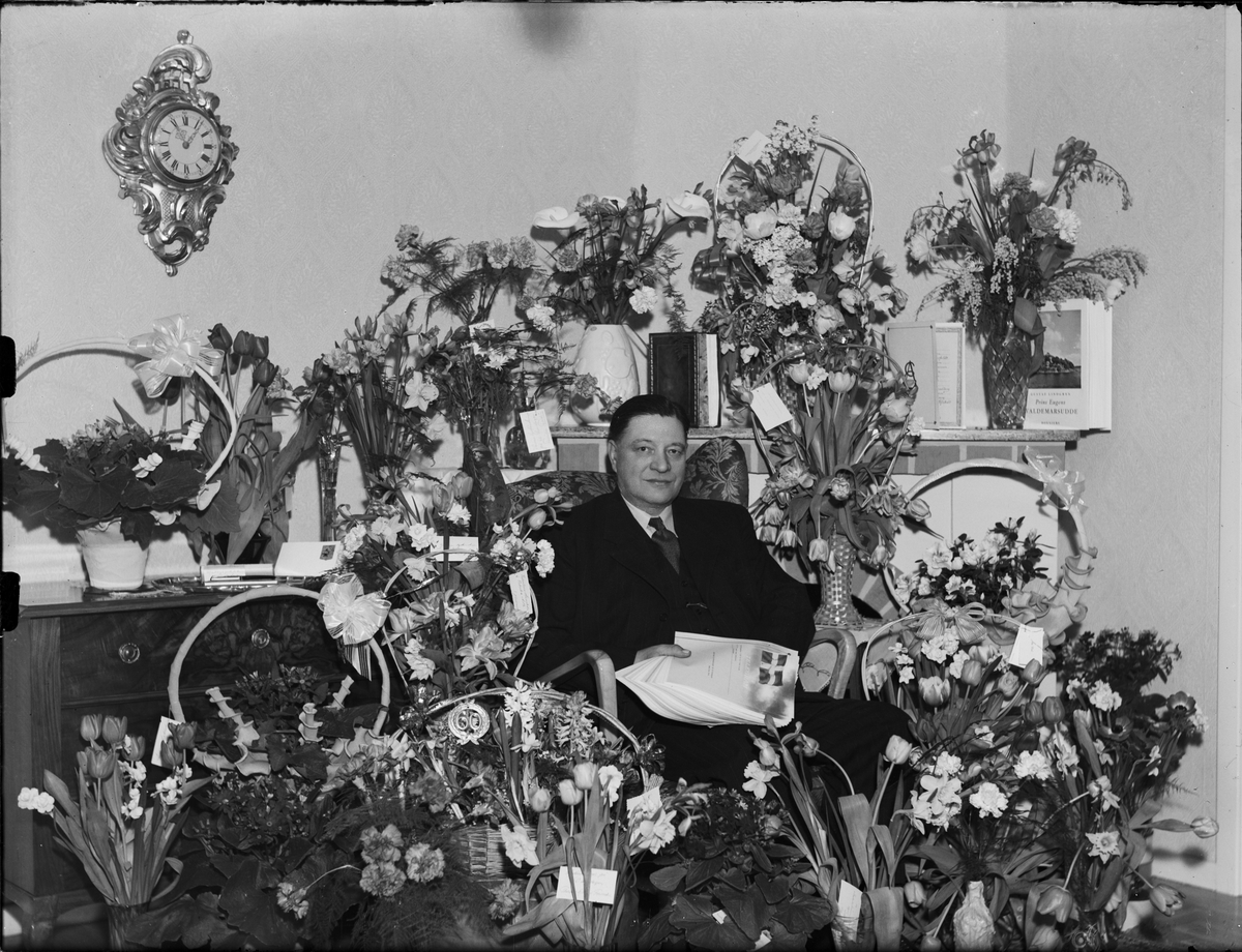 Järnhandlare Axel Eriksson omgiven av blommor firar 60-årsdag, Östhammar, Uppland 1949
