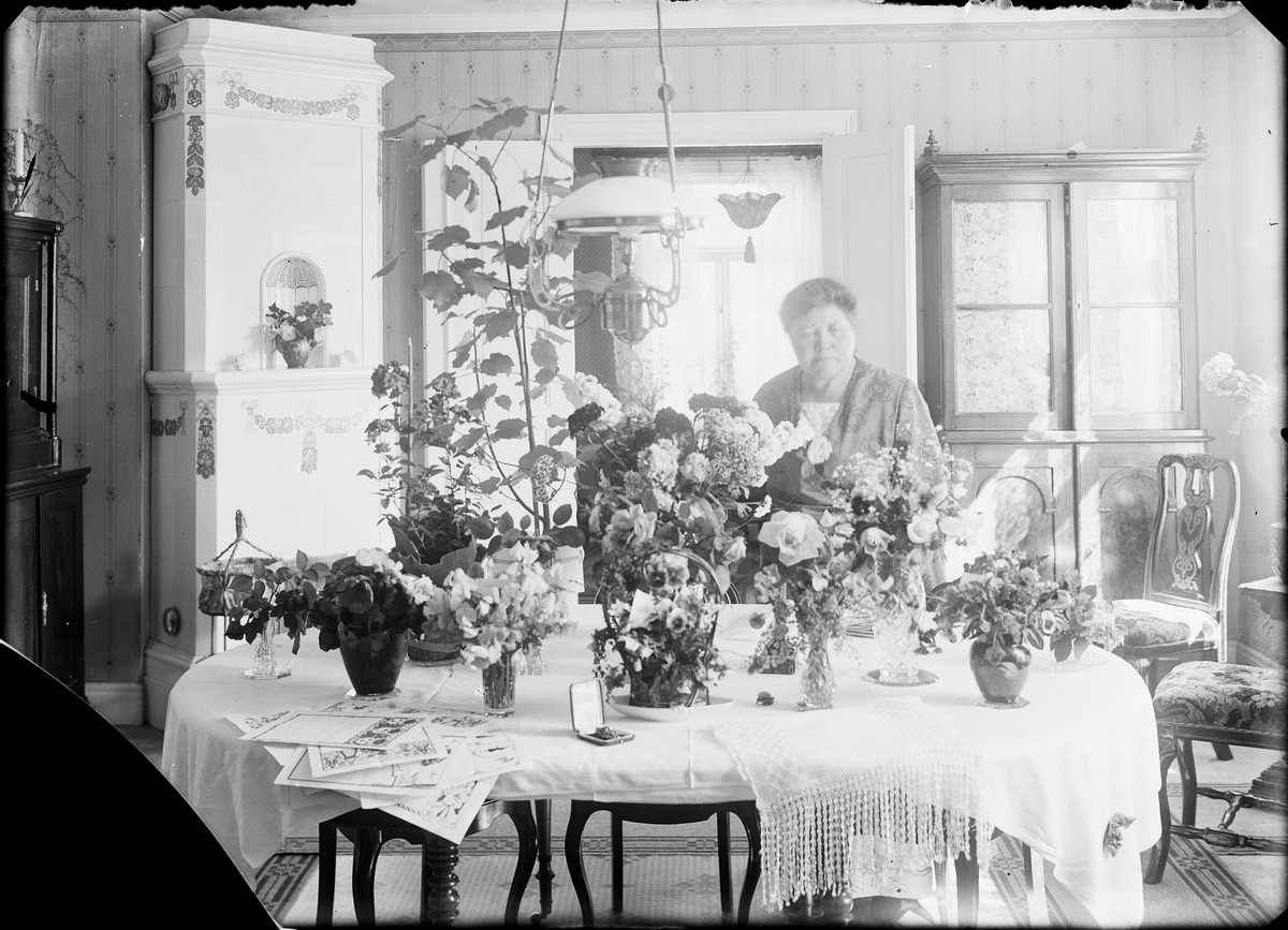 Brita Edhlund vid ett bord med blommor och telegram, Östhammar, Uppland