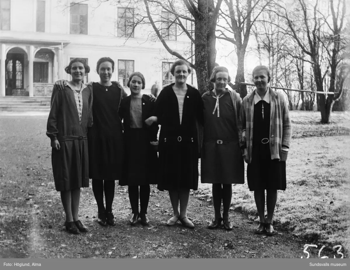 Gruppbild med fem unga kvinnor samt en lite äldre (lärarinna?). Troligen ett skolfoto, i bakgrunden syns Hussborgs herrgård. Andra kvinnan från vänster är Hilma Höglund, Stöde.