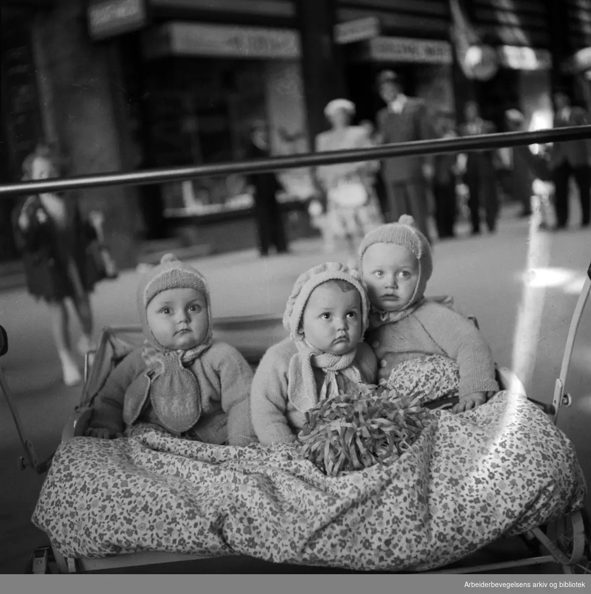 Folketeaterpassasjen. Tre barn i en barnevogn. 17. mai 1951.