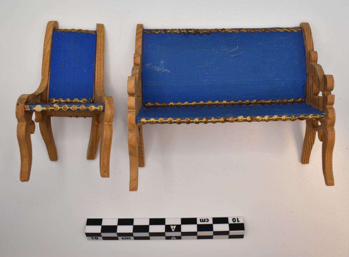Anmärkningar: Dockskåpsmöbel bestående av buffé med spegel, soffa, stol, bord. Buffén består av ett skåp med 2 dörrar. På skåpet står en spegel med lövsågningsram. Trävit dekorerad med blå pappband med gulddekor Skåpets H. 7,5 cm Br. 10 cm Dj. 4,7 cm Tot .H med spegel. 15,6 cm Soffa med armstöd (lövsågningsarbete) Rygg och Sits klädda med blått papper dekorerade med bårder av guldpapper. Ryggh. 9 cm Sitth 4 cm L 10, 9 cm  Dj. 3, 7 cm Stol av trä med sits och rygg klädda med blått papper, kanterna dekorerade med remsor av guldpapper. Ryggh. 9 cm Sitth. 4,1 cm Bord med oval skiva. Står på svarvad pelare med 3 ben. H 6, 5 cm skivans L. 9, 6 cm Br. 6,8 cm Neg.Nr.X-2691.