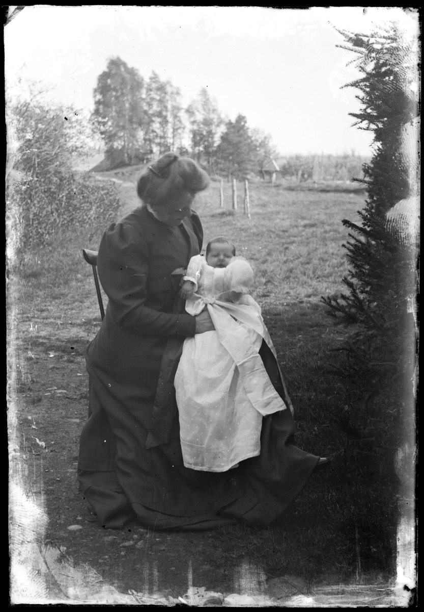 Kvinna med barn i dopklänning