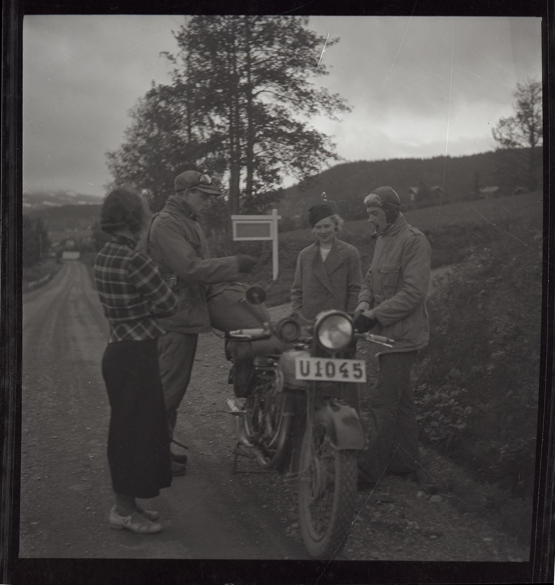 Två kvinnor beundrar en motorcykel och de två "knuttarna".